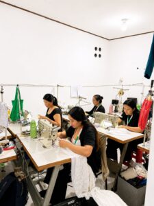 Skilled seamstresses working on sewing machines at MARI Garment manufacturer workshop in Bali, ensuring premium clothing production. About sewing production team at MARI Sititch