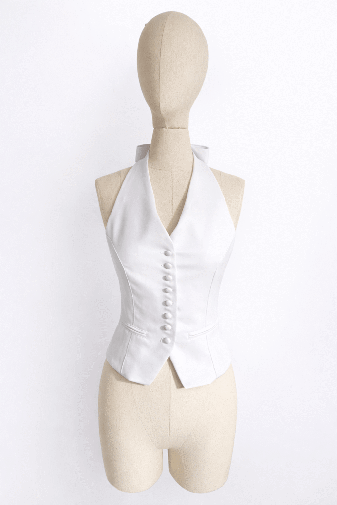 Chic white halter neck vest with button detailing, custom produced by MARI Garment manufacturer in Bali.